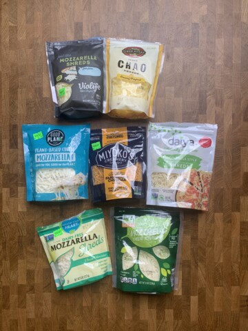 An assortment of vegan shredded cheese packages on a table.