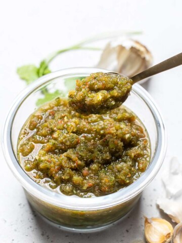 A spoonful of Puerto Rican Sofrito over a bowl.