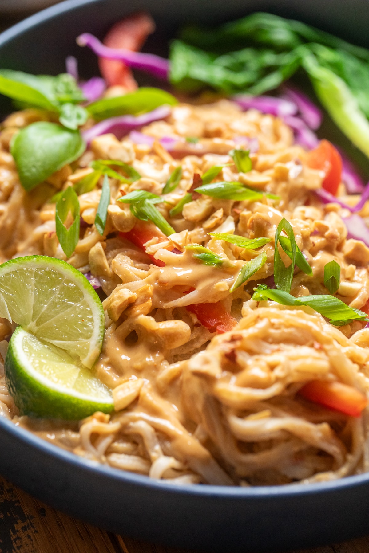 close up of vegan thai peanut noodles in a bowl.