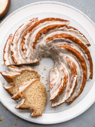Vegan banana bundt cake with icing and two slices cut.