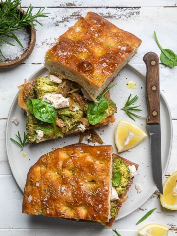 A plate with a no knead rosemary focaccia broccoli and mozzarella sandwich.